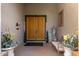 Elegant entryway with double wood doors, a bench, and decorative plants at 11957 N 140Th Ln, Surprise, AZ 85379