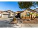 Tan two-story house with three-car garage, landscaping, and palm trees at 11957 N 140Th Ln, Surprise, AZ 85379