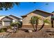 One-story house with two-car garage and desert landscaping with palm trees at 11957 N 140Th Ln, Surprise, AZ 85379