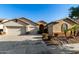 Tan two-story house with three-car garage, desert landscaping, and palm trees at 11957 N 140Th Ln, Surprise, AZ 85379