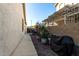 Side yard with pathway, grill, and various plants in pots at 11957 N 140Th Ln, Surprise, AZ 85379