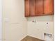 Laundry room with wooden cabinets and tile flooring at 322 E Caribbean Dr, Casa Grande, AZ 85122