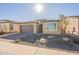 Tan colored house with a gray garage door and nicely landscaped yard at 389 E Bracciano Ave, Queen Creek, AZ 85140
