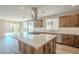 Modern kitchen with island, stainless steel appliances, and light wood cabinets at 389 E Bracciano Ave, Queen Creek, AZ 85140