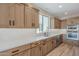 Kitchen features light wood cabinets, quartz countertops, and stainless steel appliances at 389 E Bracciano Ave, Queen Creek, AZ 85140
