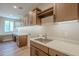 Laundry room with ample storage, a sink, and light wood cabinets at 389 E Bracciano Ave, Queen Creek, AZ 85140