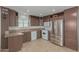 Kitchen with dark brown cabinets, stainless steel appliances, and tile flooring at 5201 W Camelback Rd # A187, Phoenix, AZ 85031