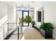 Bright and airy entryway with glass doors, light wood floors, and modern light fixtures at 6862 E Joshua Tree Ln, Paradise Valley, AZ 85253