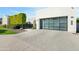 Modern garage with glass panels and herringbone driveway at 6862 E Joshua Tree Ln, Paradise Valley, AZ 85253