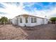 Rear view of the home showcasing a gravel yard and fire pit at 8257 E Dutchman Dr, Mesa, AZ 85208