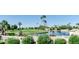 Peaceful lakefront view with lush landscaping and palm trees at 8257 E Dutchman Dr, Mesa, AZ 85208