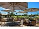 Relaxing patio with tables and umbrellas overlooking golf course at 8257 E Dutchman Dr, Mesa, AZ 85208