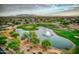 Aerial view showing a pond, fountain, and houses in a golf course community at 109 S Agua Fria Ln, Casa Grande, AZ 85194