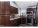 Kitchen features dark wood cabinets, granite counters, and stainless steel appliances at 4112 E Tanglewood Dr, Phoenix, AZ 85048