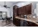 Open kitchen with dark wood cabinets and granite countertops at 4112 E Tanglewood Dr, Phoenix, AZ 85048