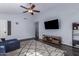 Spacious living room with dark hardwood floors, sectional sofa and large TV at 4112 E Tanglewood Dr, Phoenix, AZ 85048