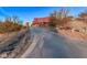 Long concrete driveway leading to a red two-story home with desert landscaping at 13437 N 16Th N Pl, Phoenix, AZ 85022