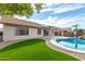 Landscaped backyard with a pool and artificial turf at 15016 W Honeysuckle Ln, Surprise, AZ 85374