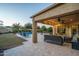 Covered patio with seating area, adjacent to a refreshing pool at 8338 N 180Th Dr, Waddell, AZ 85355