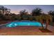 Night view of refreshing backyard pool with water features and lounge chairs at 8338 N 180Th Dr, Waddell, AZ 85355