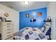 Blue bedroom with dresser and sports themed decor at 2438 E Atlanta Ave, Phoenix, AZ 85040