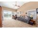 Spacious living room featuring a gray sofa and sliding glass doors at 15351 W Port Royale Ln, Surprise, AZ 85379