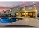 Inviting backyard oasis featuring a sparkling pool, expansive patio, and string lights at 17881 W Larkspur Dr, Surprise, AZ 85388