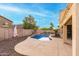 Landscaped backyard with a kidney-shaped pool and a covered patio at 17881 W Larkspur Dr, Surprise, AZ 85388