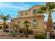 Two-story house with tan exterior, palm trees, and a three-car garage at 17881 W Larkspur Dr, Surprise, AZ 85388