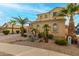 Two-story house with tan exterior, palm trees, and a three-car garage at 17881 W Larkspur Dr, Surprise, AZ 85388