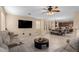 Open concept living room and kitchen with large sectional sofa and tile floors at 17881 W Larkspur Dr, Surprise, AZ 85388