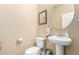 Updated bathroom with pedestal sink, oval mirror, and beige walls at 33242 N Jamie Ln, San Tan Valley, AZ 85144