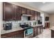 Kitchen with granite countertops, stainless steel appliances and dark wood cabinets at 33242 N Jamie Ln, San Tan Valley, AZ 85144