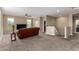 Spacious loft area with plush brown couch, carpet, and ceiling fan at 33242 N Jamie Ln, San Tan Valley, AZ 85144