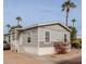 Gray manufactured home with landscaping and a carport at 625 W Mckellips Rd # 213, Mesa, AZ 85201