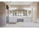 Bathroom with double sinks, large mirror, and bathtub at 744 W Desert Broom Dr, Chandler, AZ 85248