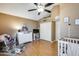 Well-lit bedroom with hardwood floors, crib, and white dresser at 8111 W Wacker Rd # 116, Peoria, AZ 85381