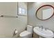 Half bath or powder room with pedestal sink and modern circular mirror at 1550 E Redfield Rd, Phoenix, AZ 85022