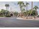 Community clubhouse with palm trees and circular driveway at 24612 S Starcrest Dr, Sun Lakes, AZ 85248