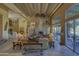 Living area showcasing a stone fireplace, wood beams, and access to backyard at 3110 Arroyo Hondo --, Carefree, AZ 85377