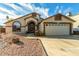 House exterior featuring a two-car garage and well-maintained landscaping at 2606 N 89Th Dr, Phoenix, AZ 85037