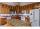 Well-equipped kitchen with granite countertops and wood cabinetry at 2606 N 89Th Dr, Phoenix, AZ 85037