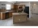 Kitchen with wood cabinets, a large island, black appliances, and tile flooring at 3210 W Saint Catherine Ave, Phoenix, AZ 85041