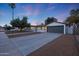 Single story home with a gray garage door and a nicely landscaped yard at 3502 E Janice Way, Phoenix, AZ 85032