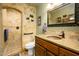 Spa-like bathroom with walk-in shower, stone tile, and updated vanity at 5701 N 105Th Ln, Glendale, AZ 85307