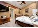 Main bedroom with a rustic wooden bed frame, and ensuite bathroom access at 5701 N 105Th Ln, Glendale, AZ 85307
