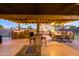 Outdoor kitchen, dining area, and fire pit under covered patio at 5701 N 105Th Ln, Glendale, AZ 85307