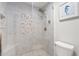 Large walk-in shower with tile surround and pebble floor at 7710 E Gainey Ranch Rd # 157, Scottsdale, AZ 85258