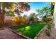 Landscaped backyard with a grassy area and rock border at 937 E Knight Ln, Tempe, AZ 85284