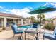 Relaxing poolside patio furniture under an umbrella at 17433 W Statler St, Surprise, AZ 85388